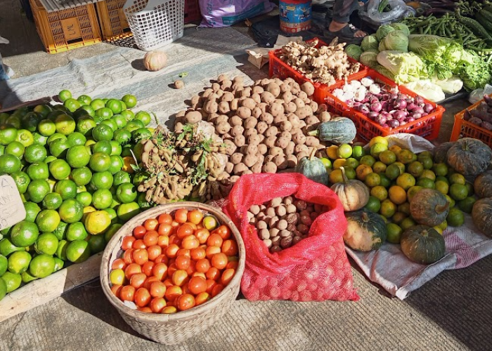Colorful fresh produce at a Philippine palengke including tomatoes, calamansi, squash, onions, and ginger